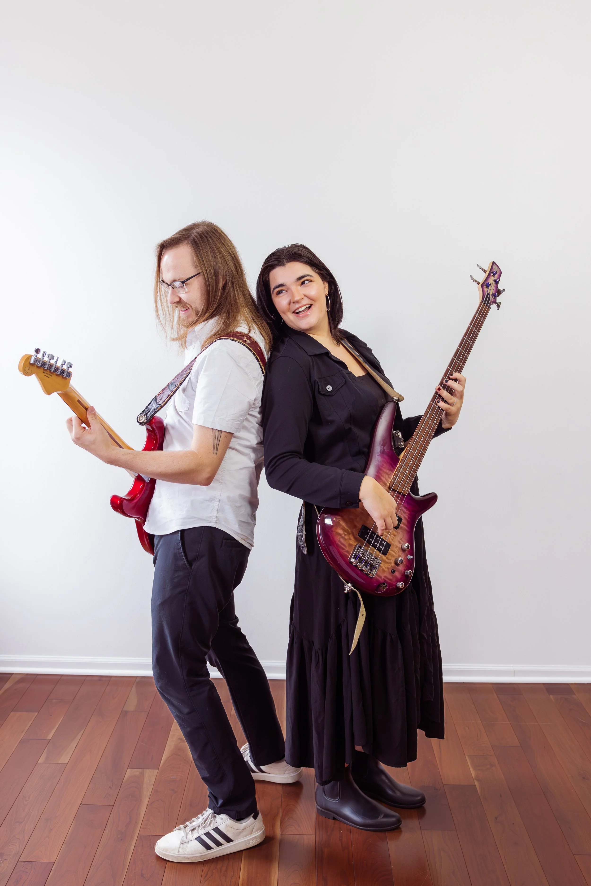 The Heartbeats Metro Detroit Wedding and Event Band standing back to back, each holding an electric guitar.