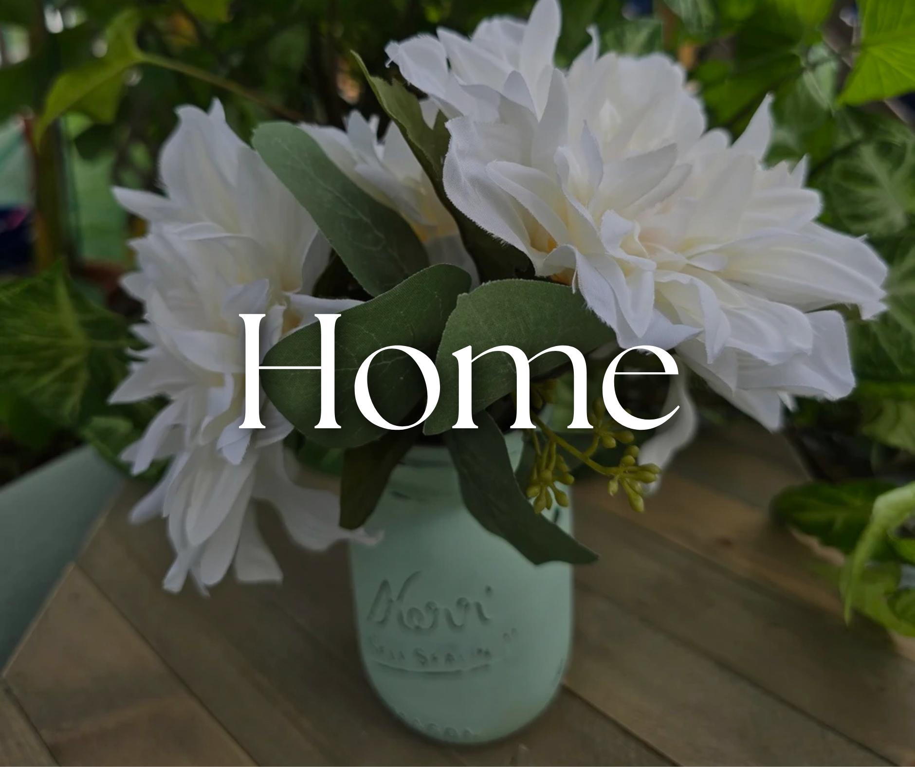White flowers in a light blue vase with the word 'Home' overlayed on the image.