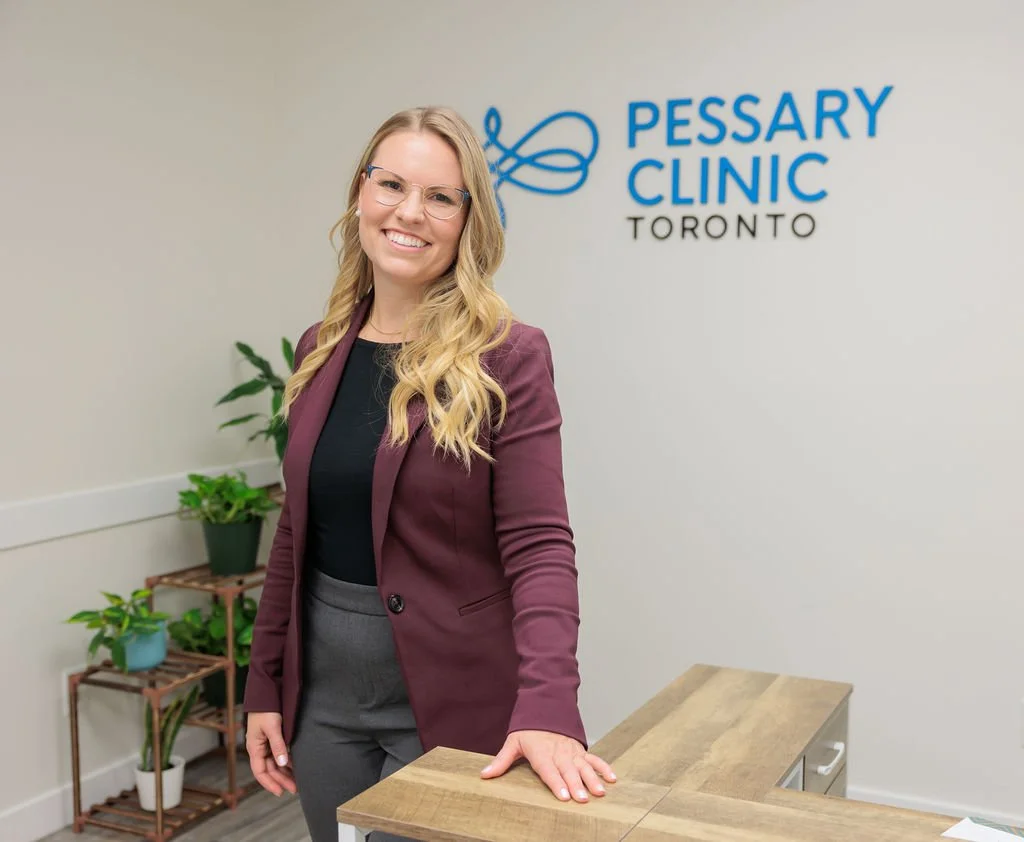 Pelvic health clinician standing at the front desk inside Toronto Pessary Clinic.