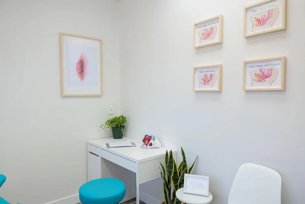Private pelvic floor physiotherapy exam room with anatomical artwork and a clinical desk at Toronto Pessary Clinic.