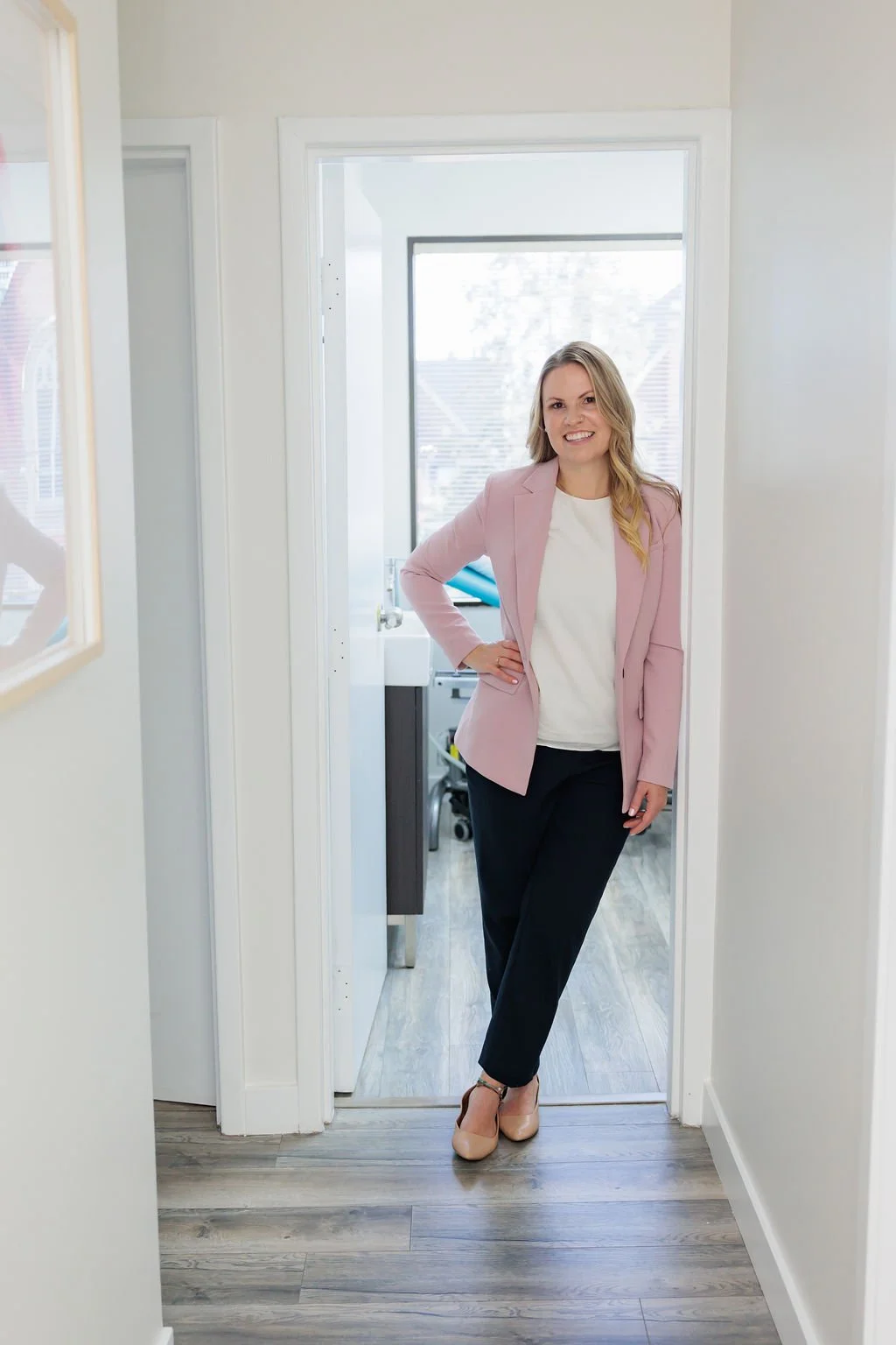 Pelvic health physiotherapist standing in the doorway of a private exam room at Toronto Pessary Clinic.