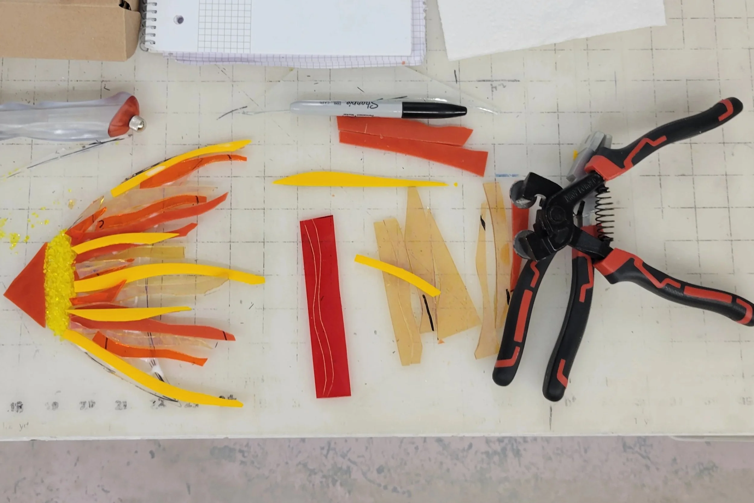 Creating the orange fish. By cutting the glass with a bit of a curve you can create movement, can be fun but also very challenging. Here I am cutting the pieces and evaluating how each piece can help with what I was trying to achieve.