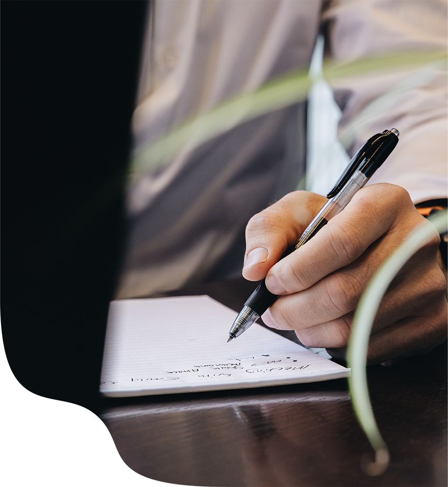 Person holding pen over paper