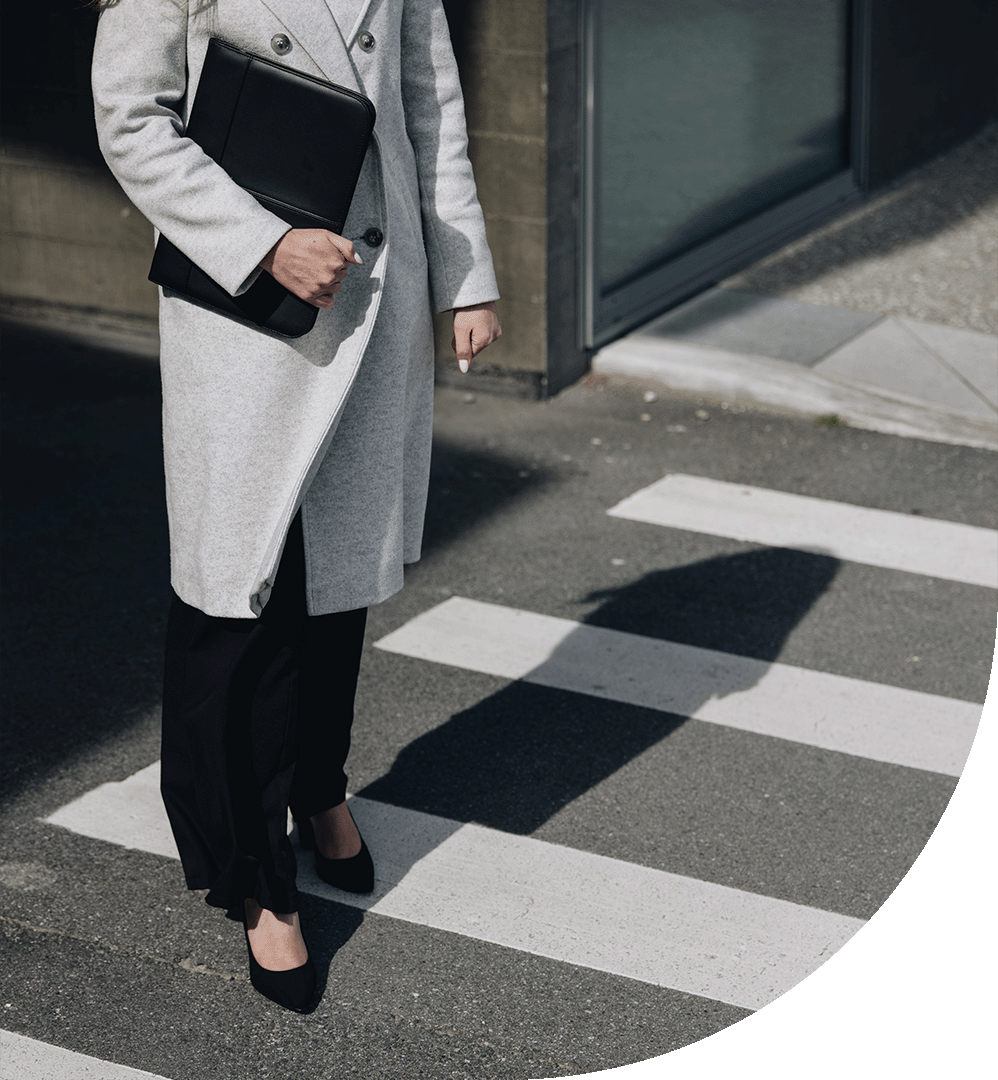 Person holding laptop while standing on pedestrian crossing