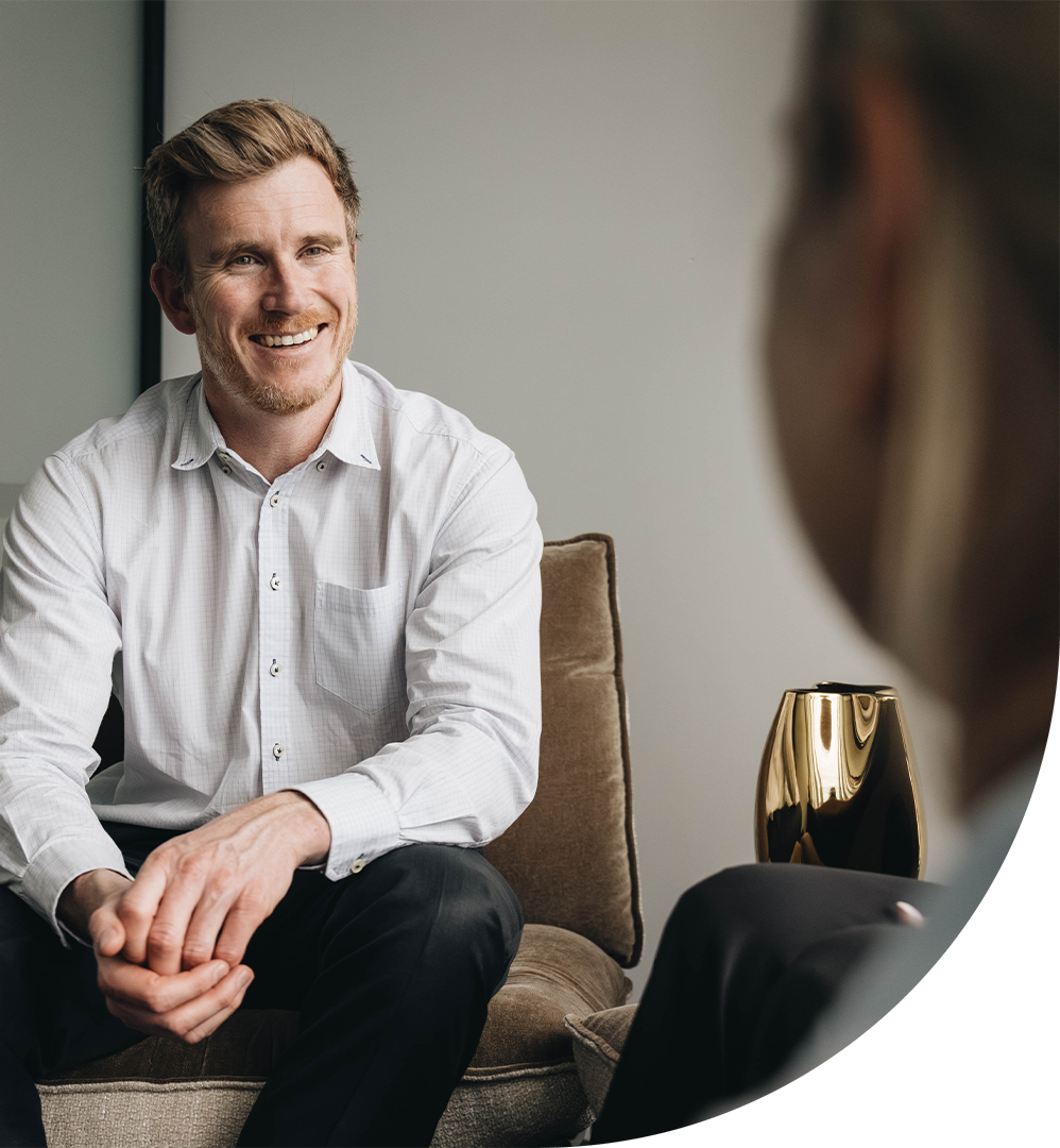 Man smiling while looking at another person