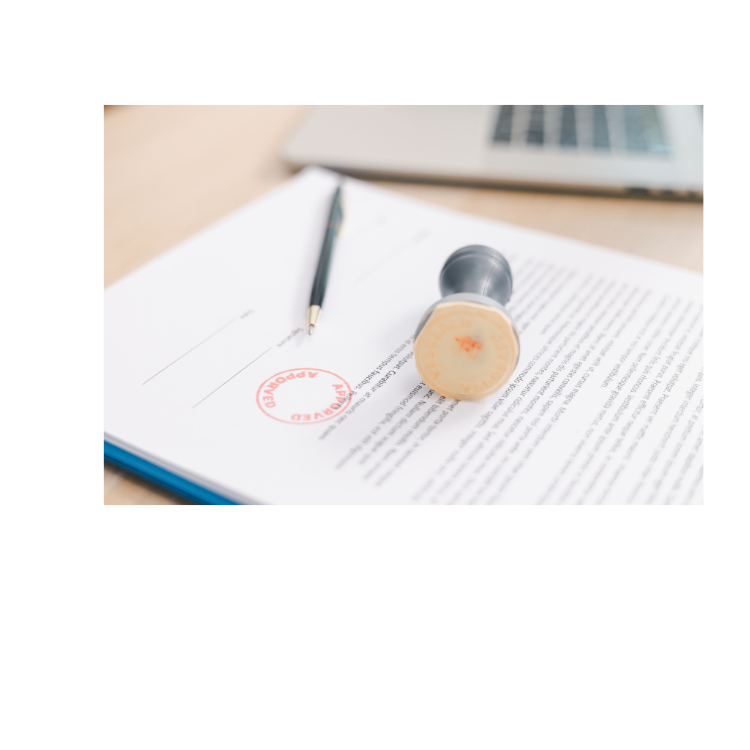 Legal document with a red stamp, a black pen, and a rubber stamp on top, on a wooden desk near a laptop.