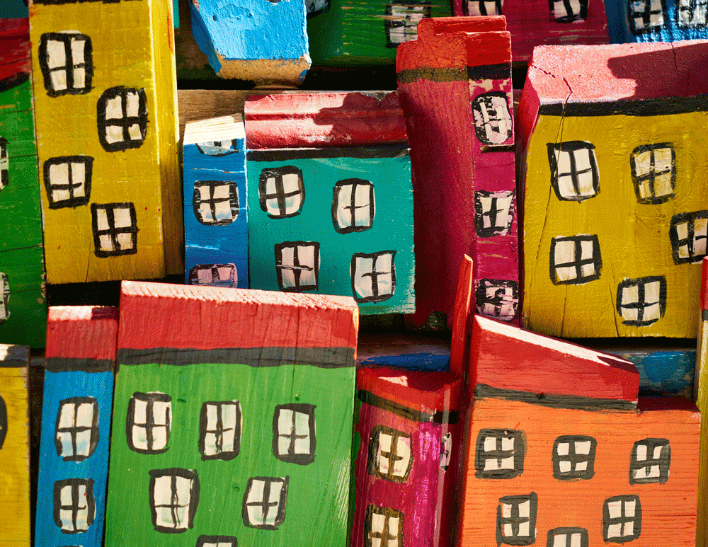 Colorful wooden blocks painted with cartoonish buildings, featuring windows and rooftops.