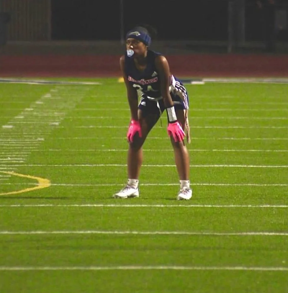 Alaiya Vaughn, women's flag football player at Steele Canyon HS. Image of Alaiya with her hands on her knees ready for a play during a game.