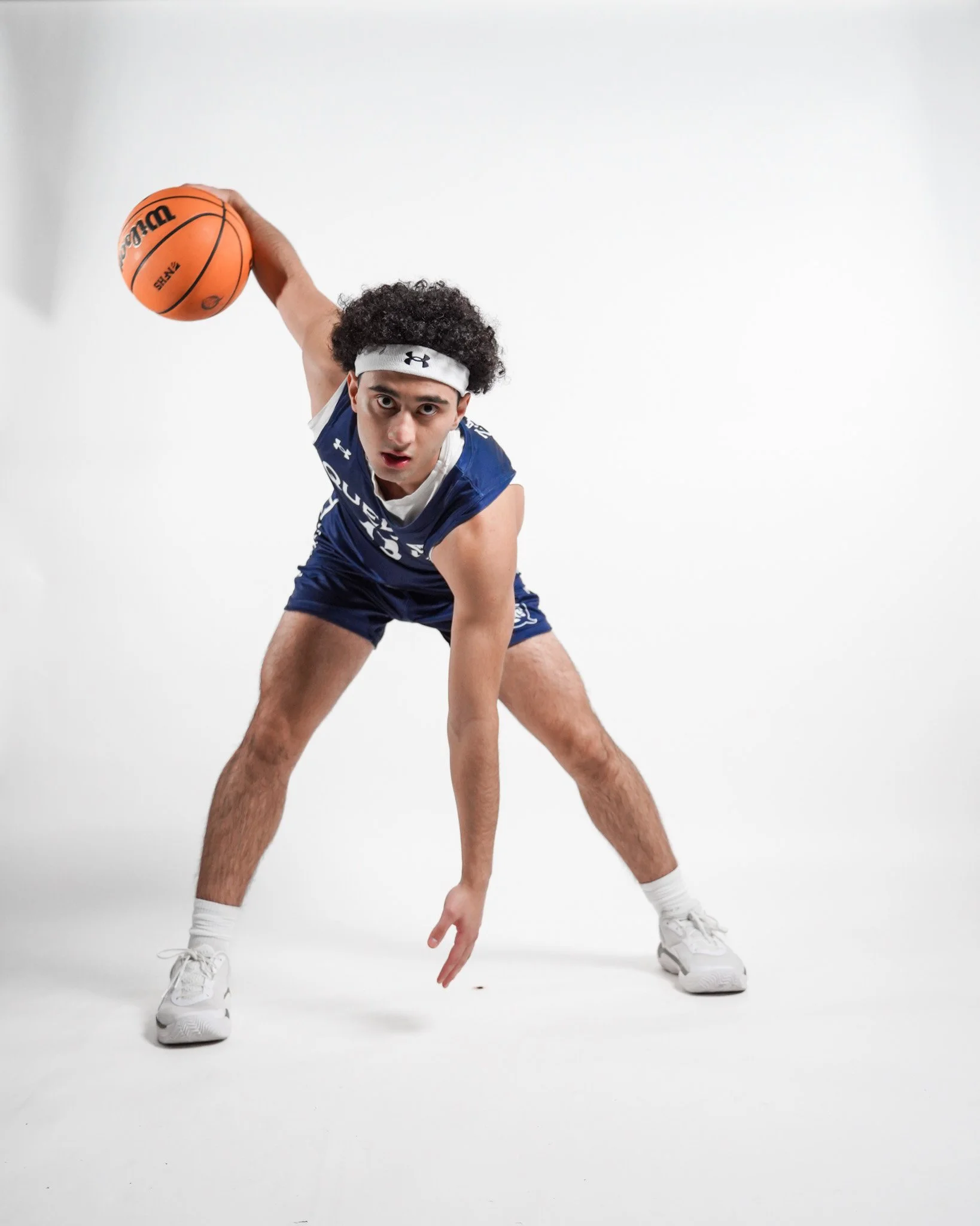 Saif Zatari, college basketball player at Queens University from Jordan. Image of Saif dribbling a ball for a media picture.