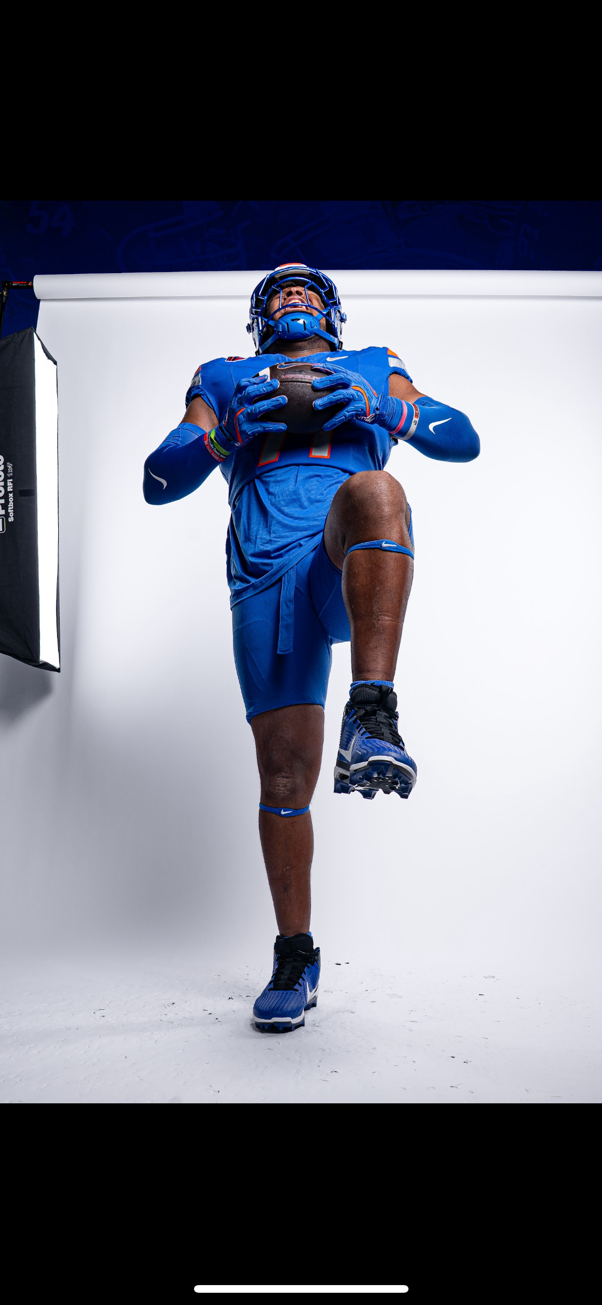 Tyler Ethridge, offensive tackle for Boise State football. Tyler is holding a ball with one knee up in a media photo.