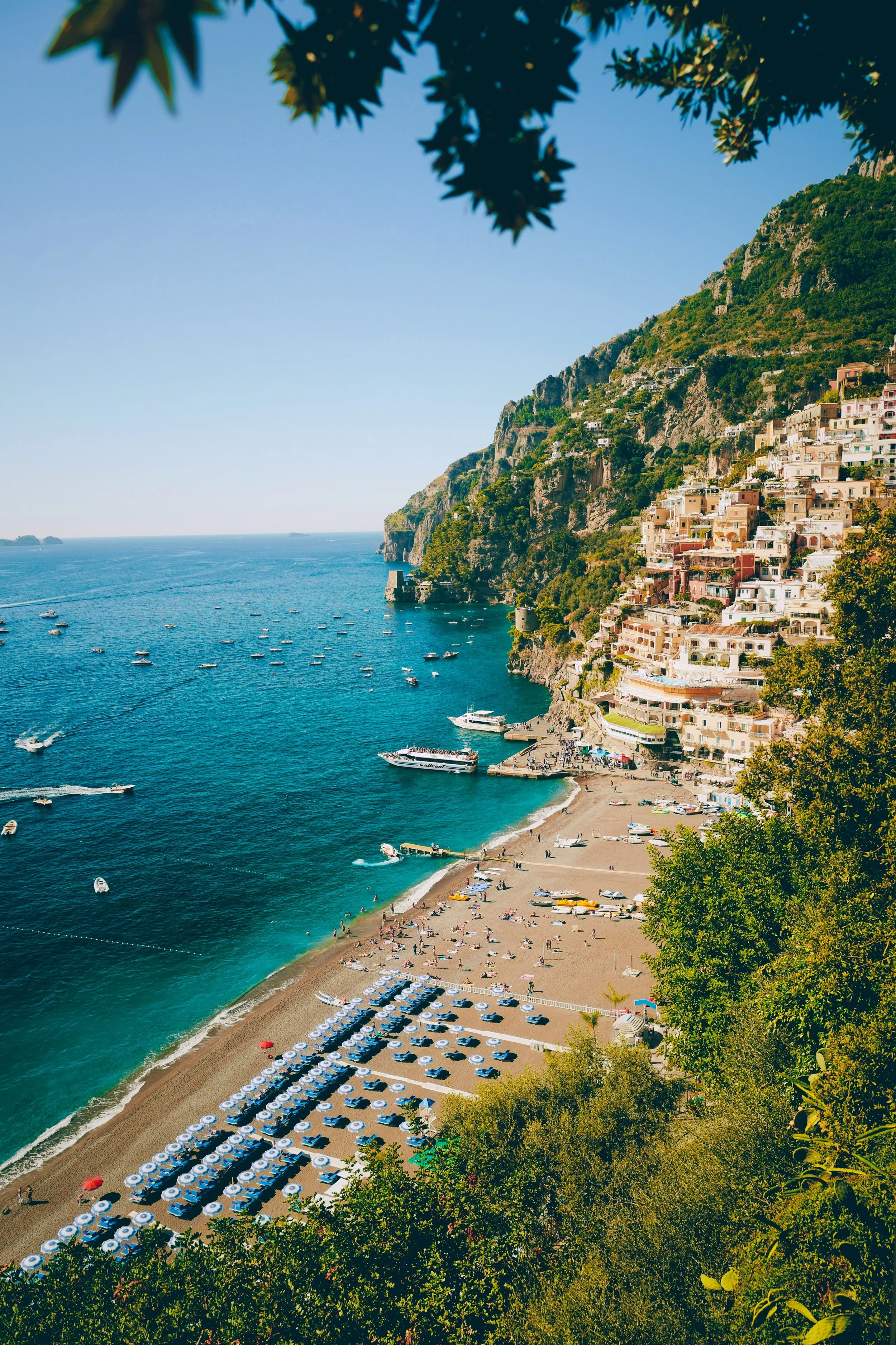 Positano beach on Amalfi Coast with colorful cliffside village buildings and turquoise Mediterranean waters