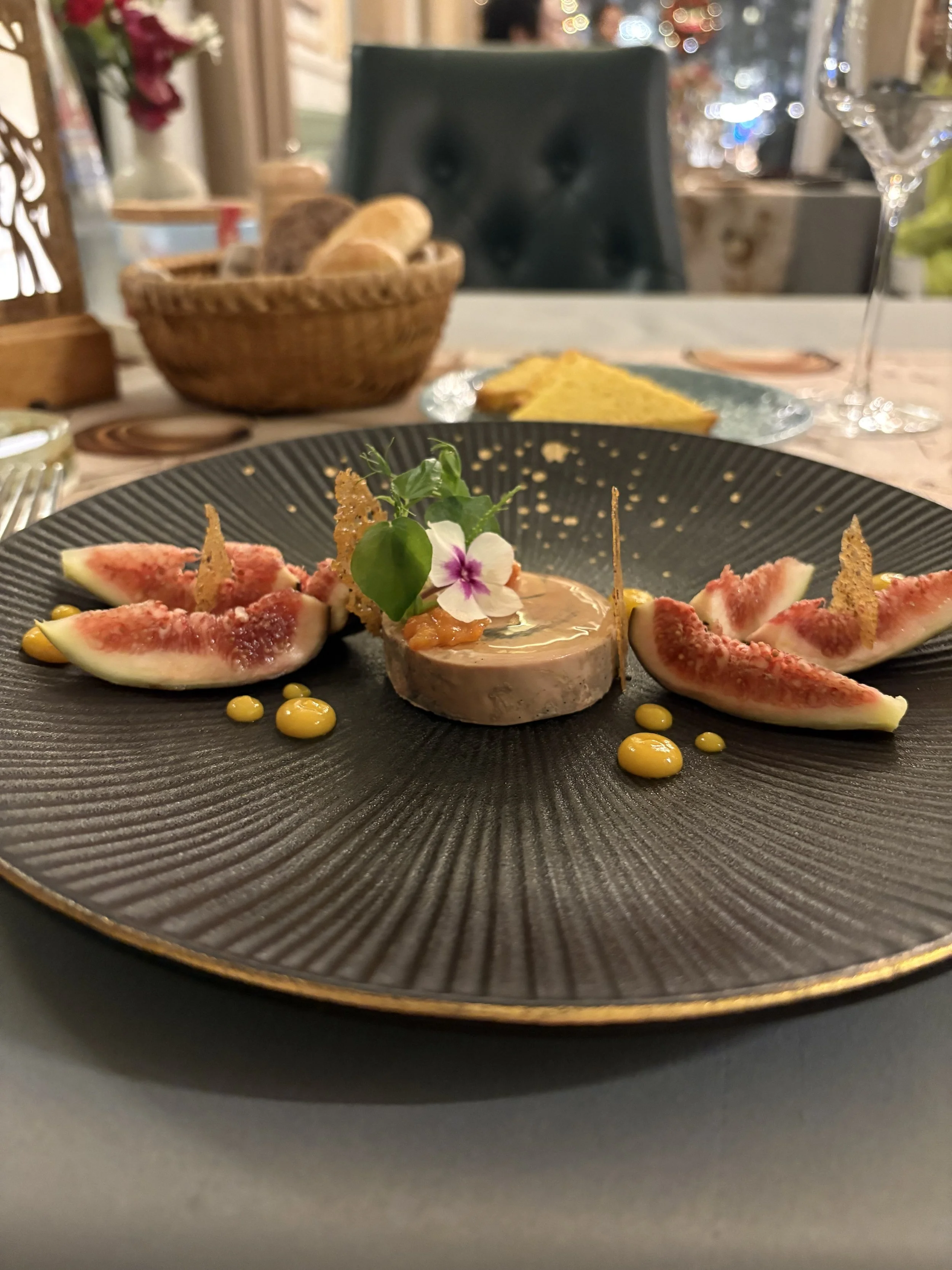 A plate with foie gras surrounded by fig slices.