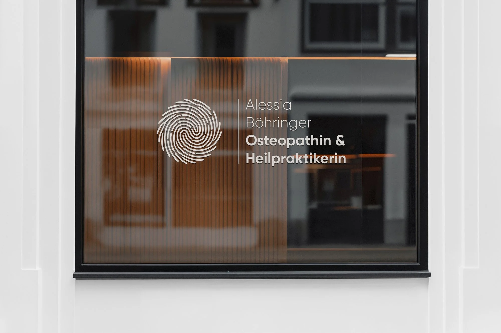 Eine Fensterscheibe auf der das Logo von Praxis Alessia Böhringer beklebt ist.