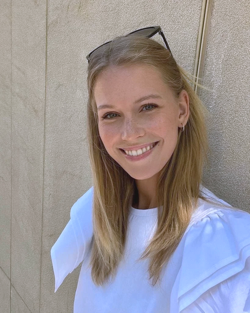 Porträt von Melanie Soler, Marketingmanagerin bei FemRide. Sie lächelt freundlich in die Kamera, trägt eine helle Bluse und steht vor einer neutralen, hellen Wand.