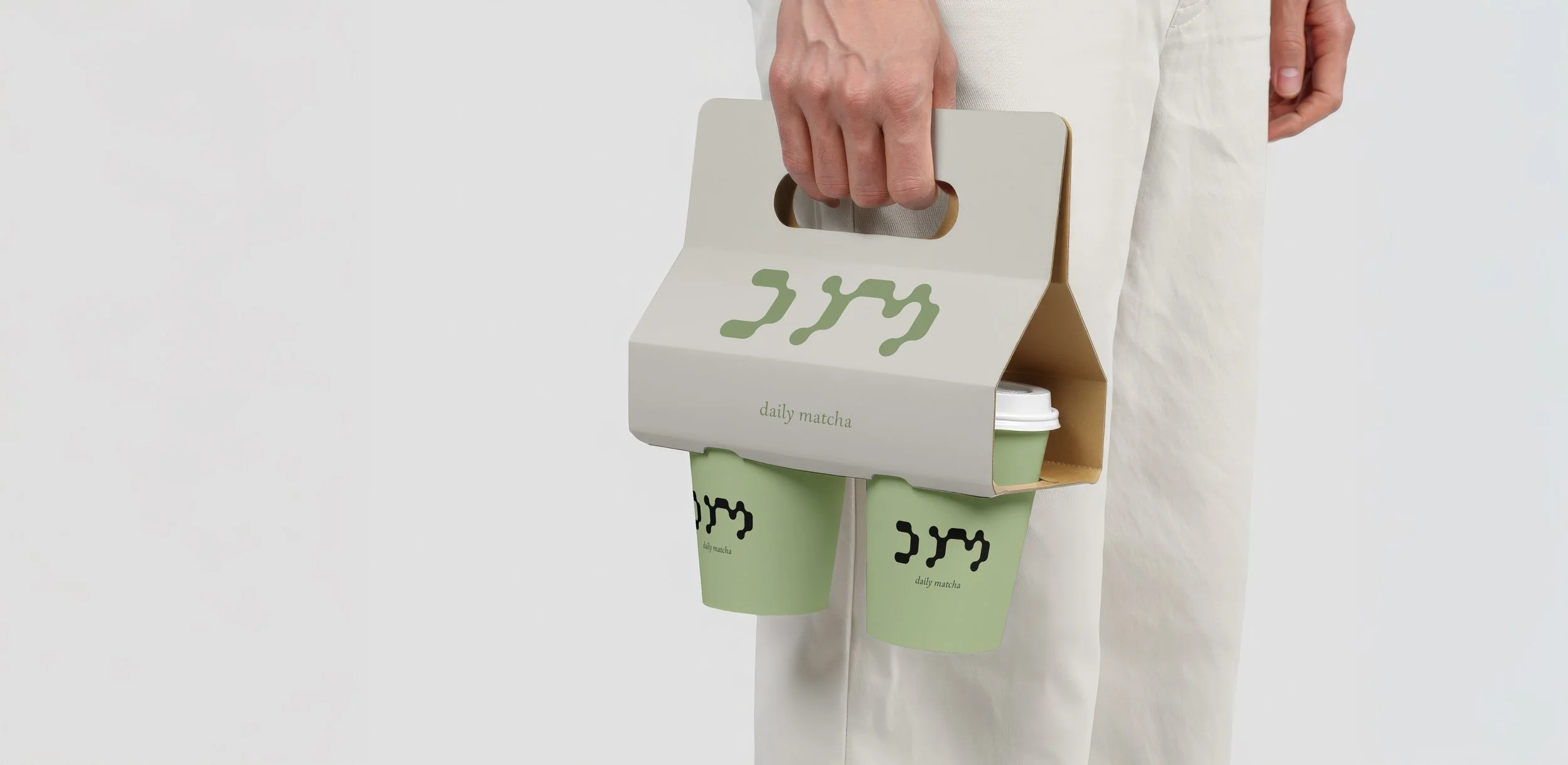 Ein To-Go Becher von Daily Matcha und eine Vorrichtung zum Transport.