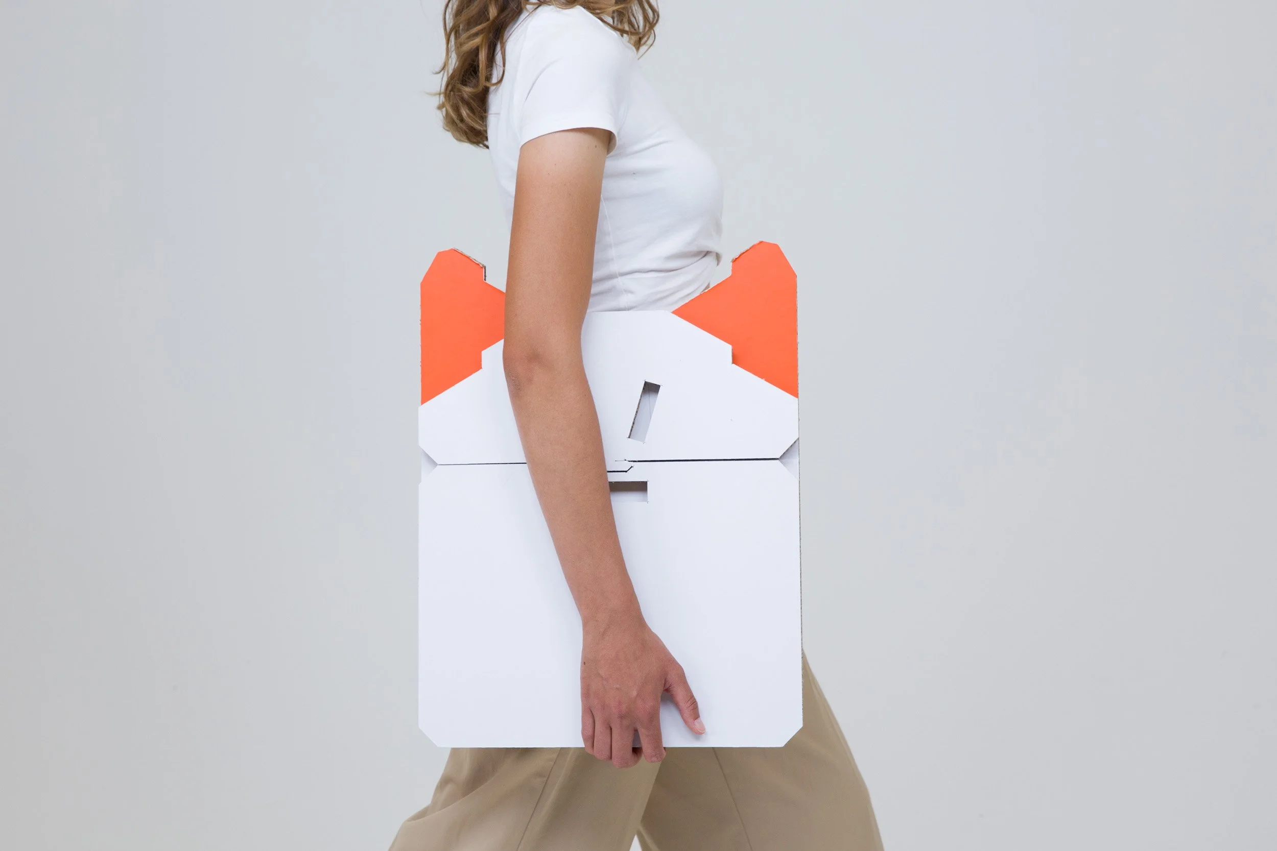 Ein Model hält ein Objekt aus Pappe in der Hand