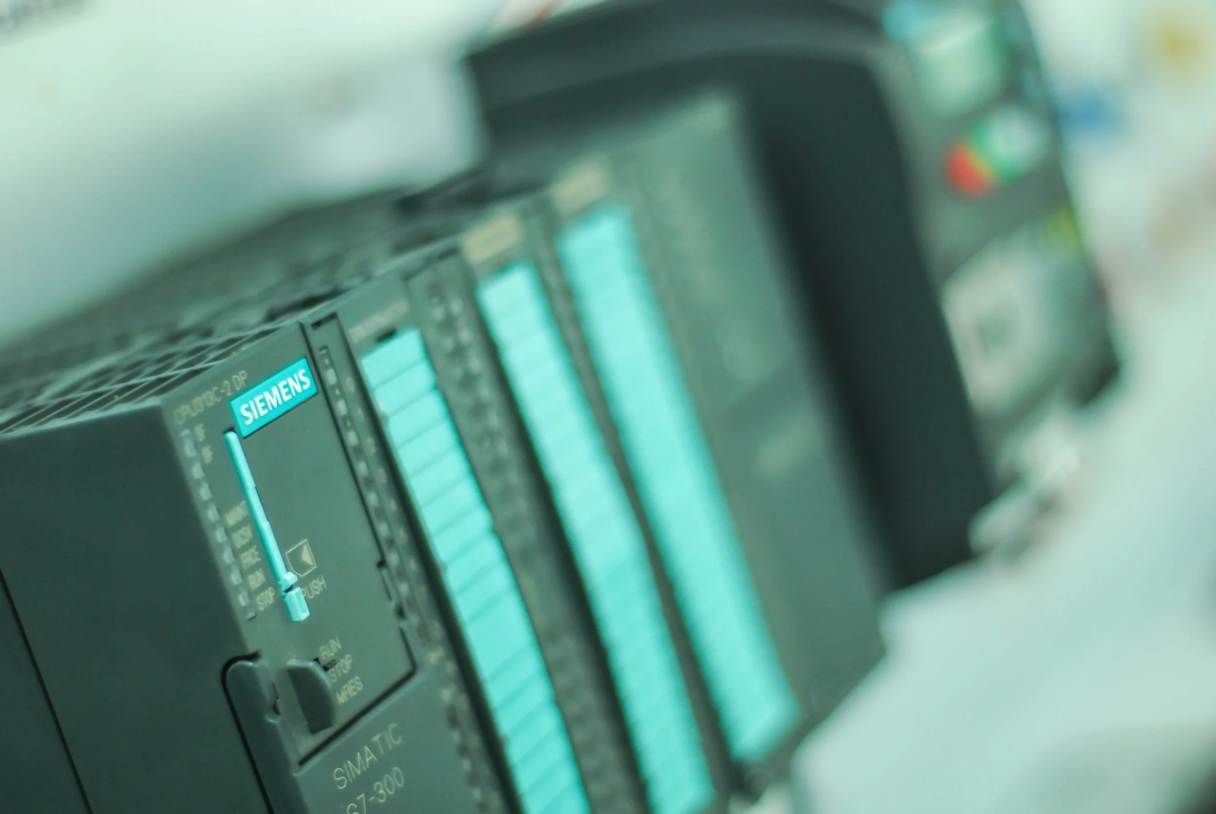 Close-up of a Siemens programmable logic controller (PLC) with a blue status indicator.