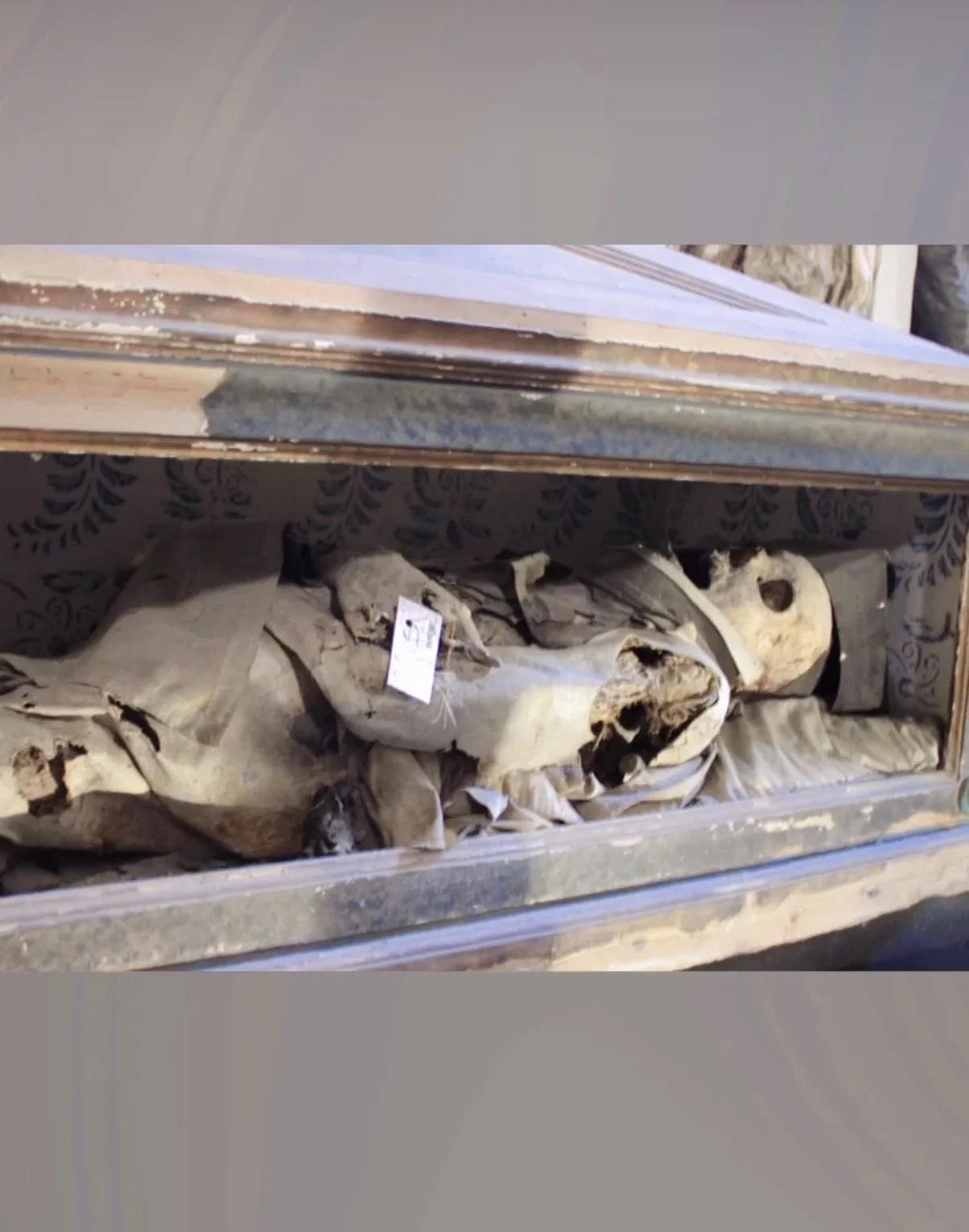 Body in open sided coffin