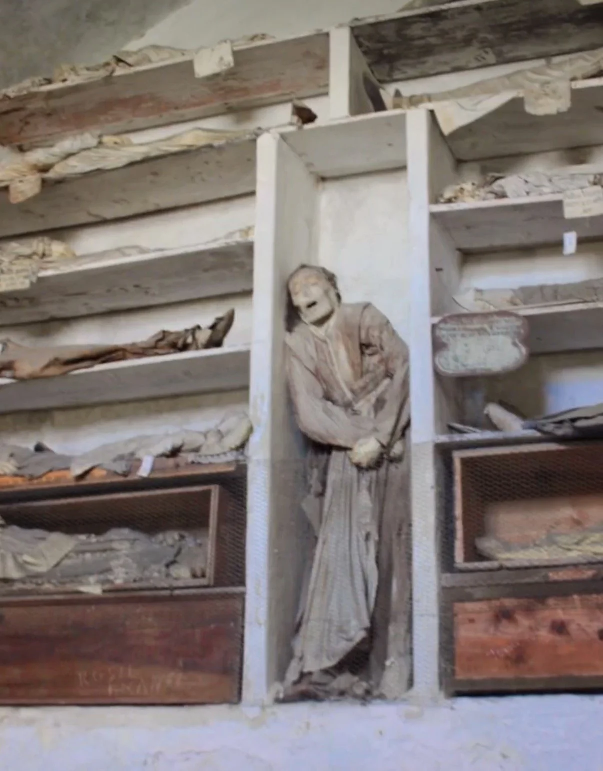 Bodies on shelving in catacombs