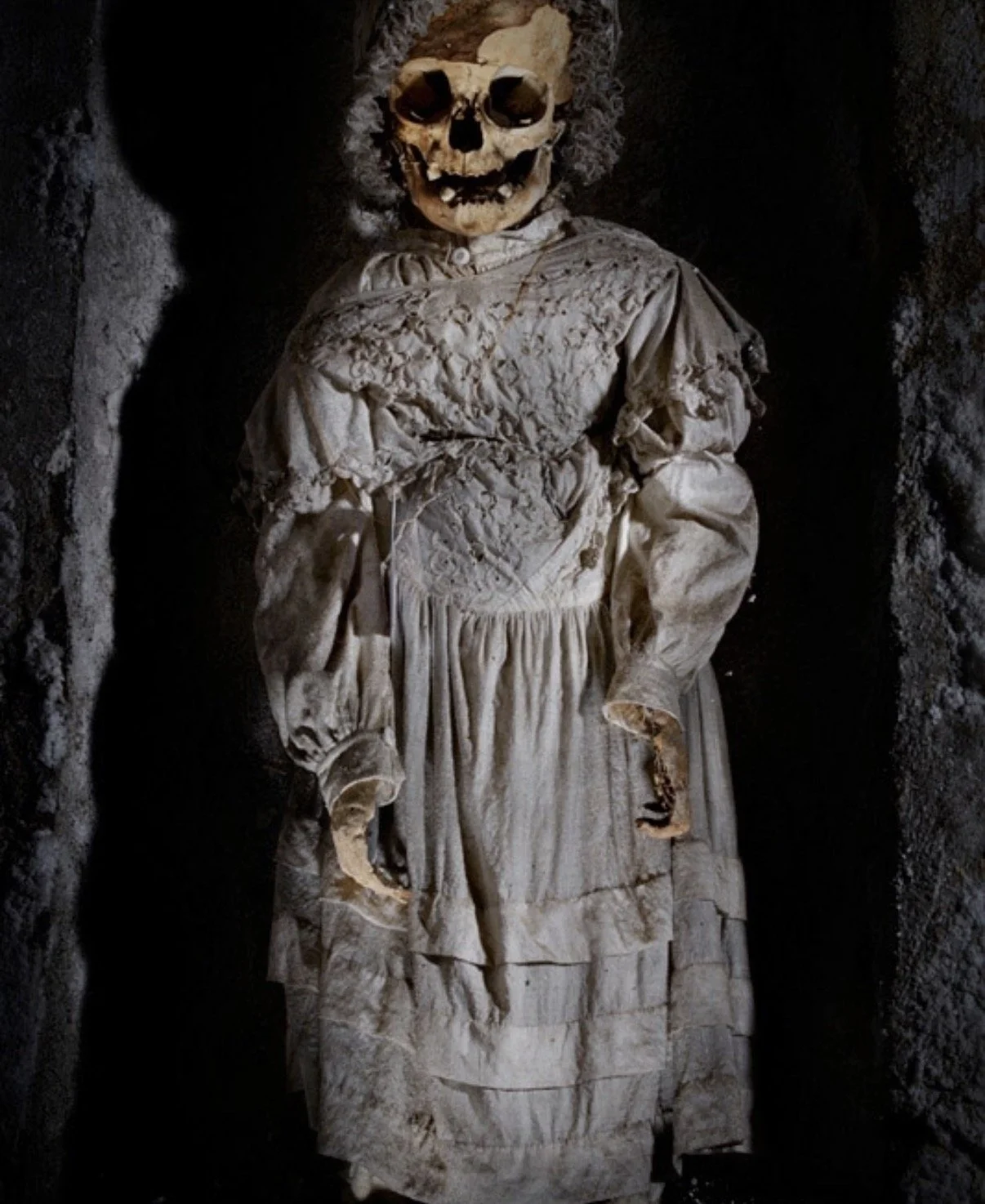 A child decayed dressed in white dress with bonnet
