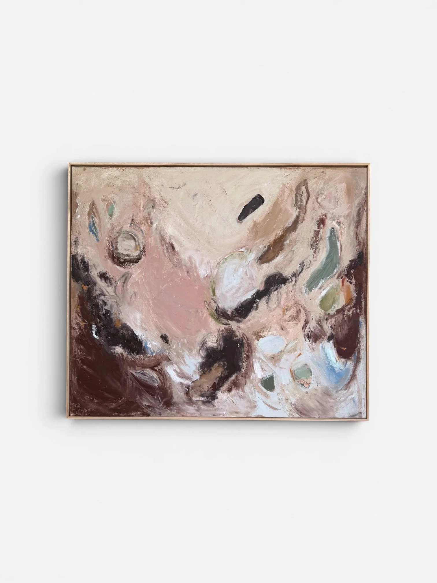 Abstract expressionist painting with swirling brushstrokes in pink, black, white, green, and blue, framed and hanging against a white wall.