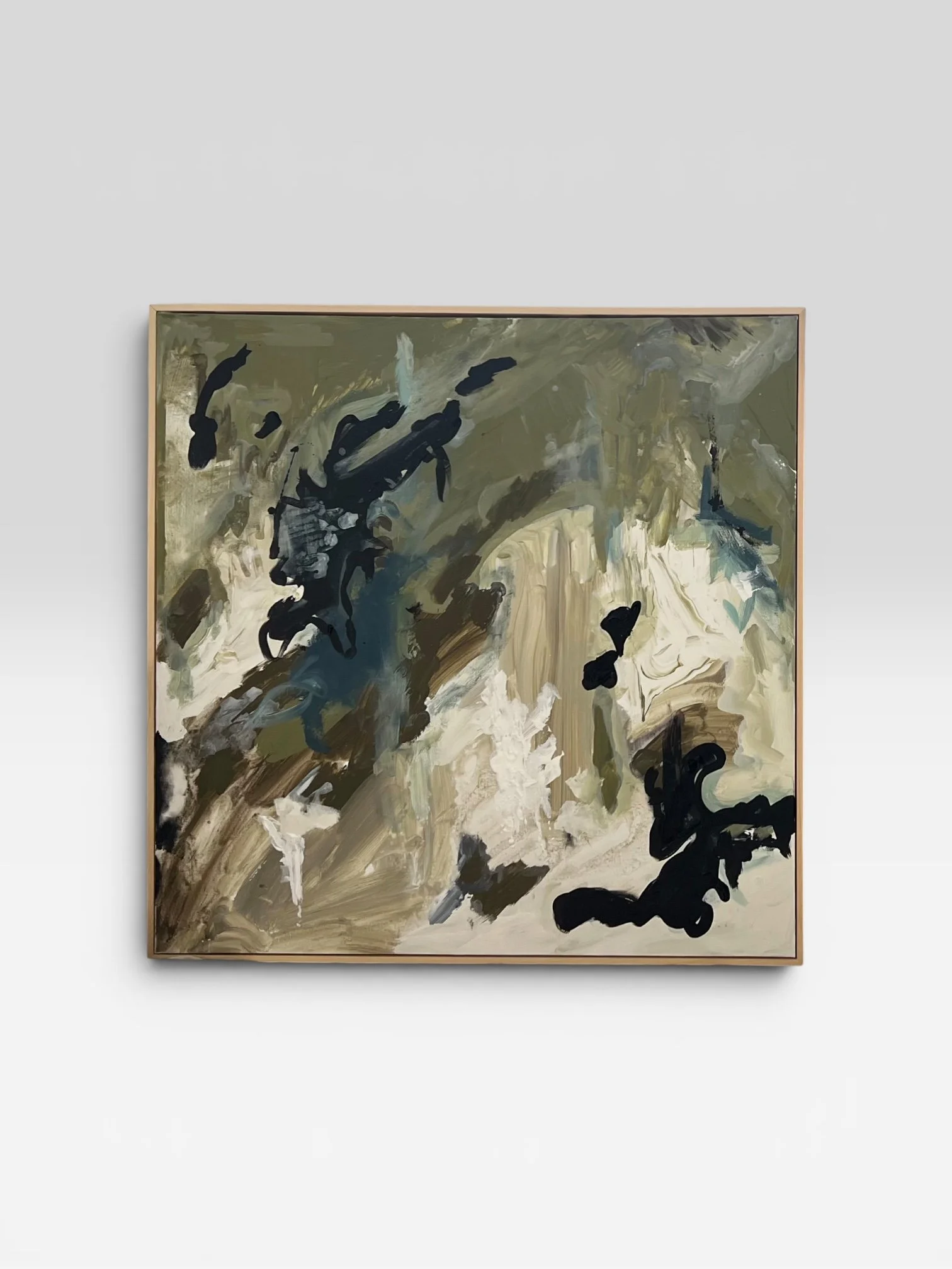An abstract painting with swirling strokes in earthy tones, black accents, and hints of blue and white, framed and displayed on a white wall.