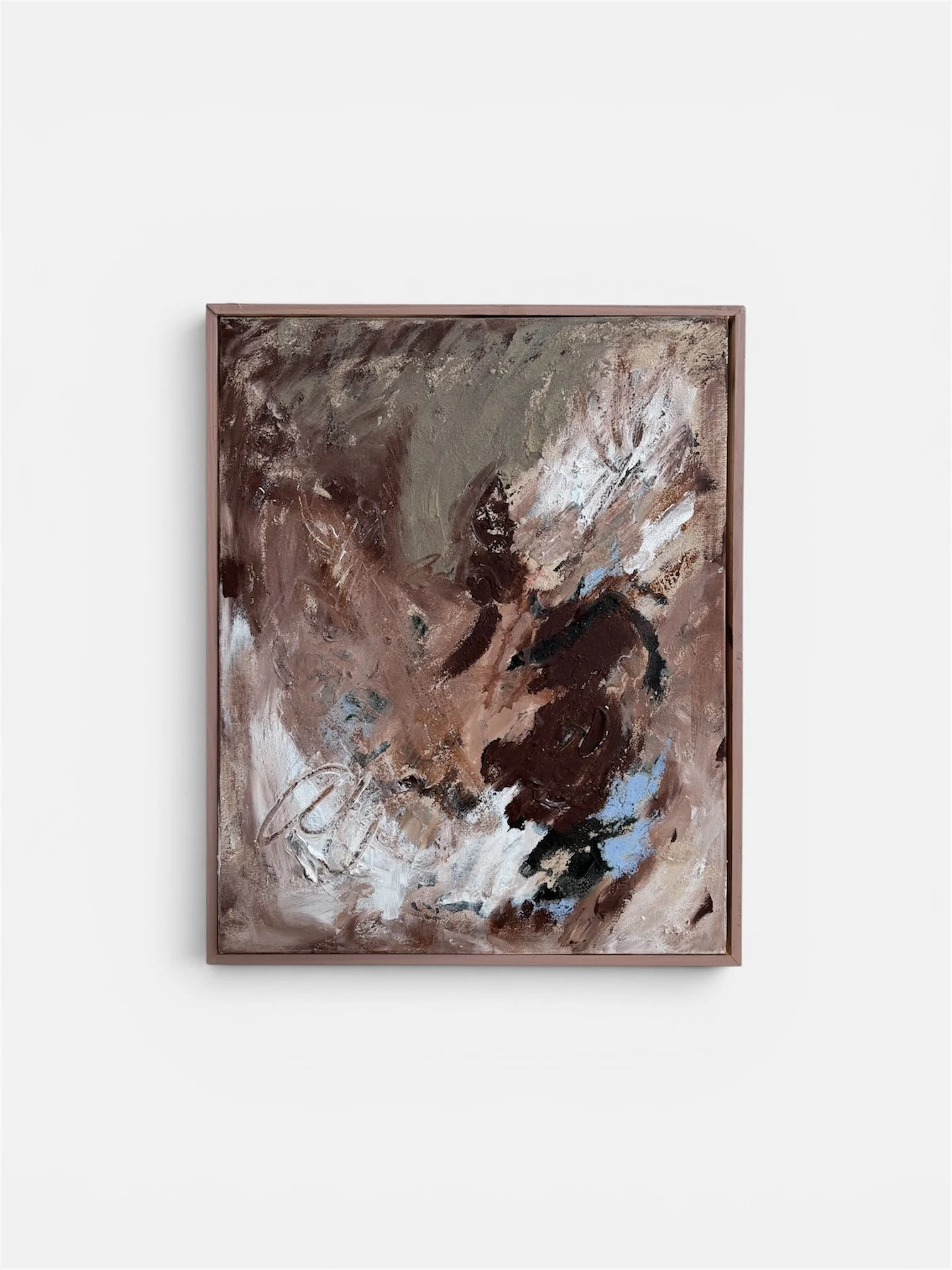 An abstract painting with earthy tones of brown, beige, black, and hints of blue, framed in a wooden frame, displayed against a white wall.