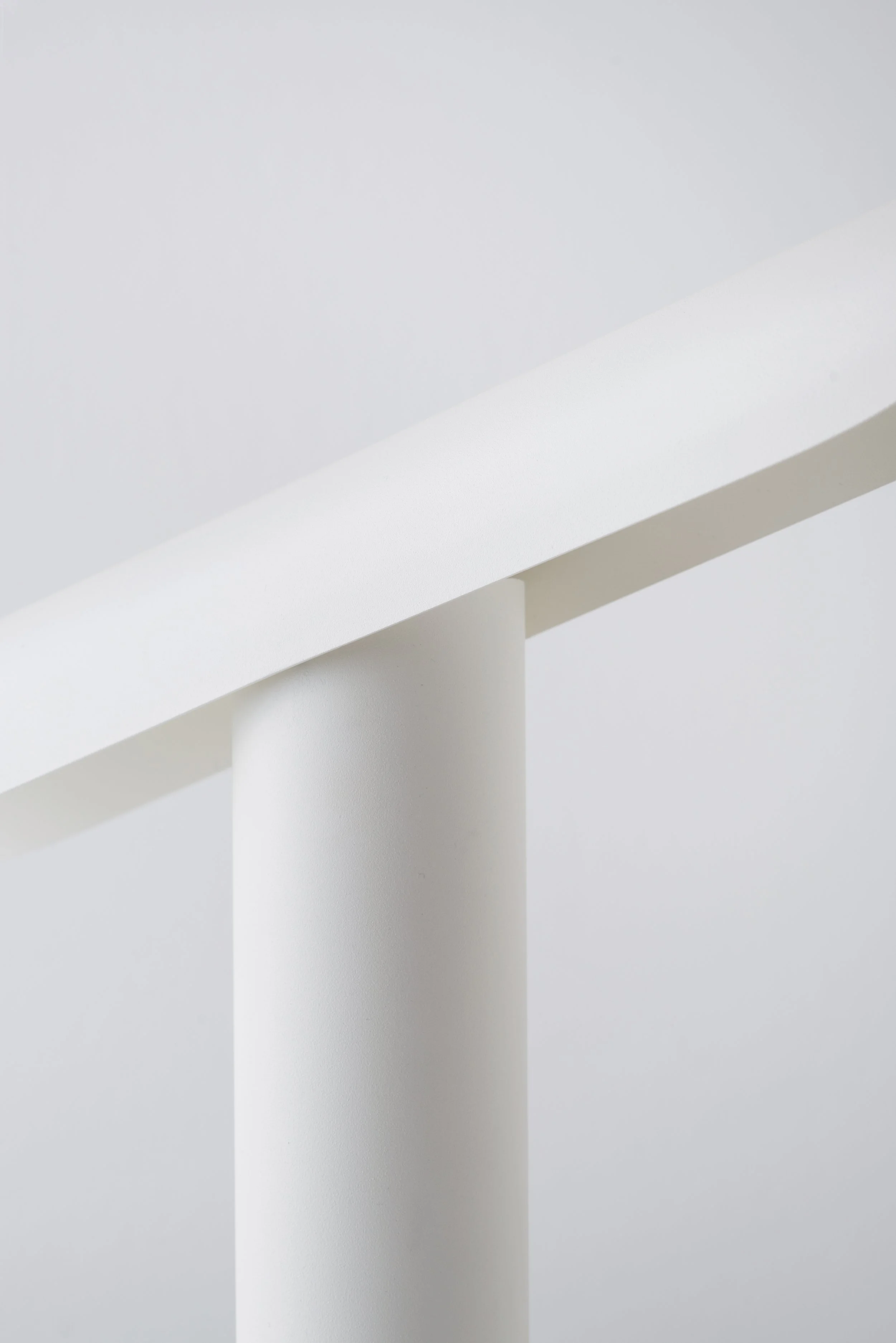 Monumental T Lamp by FRAMA with minimalist geometric shapes and functional tilting feature for directed light.