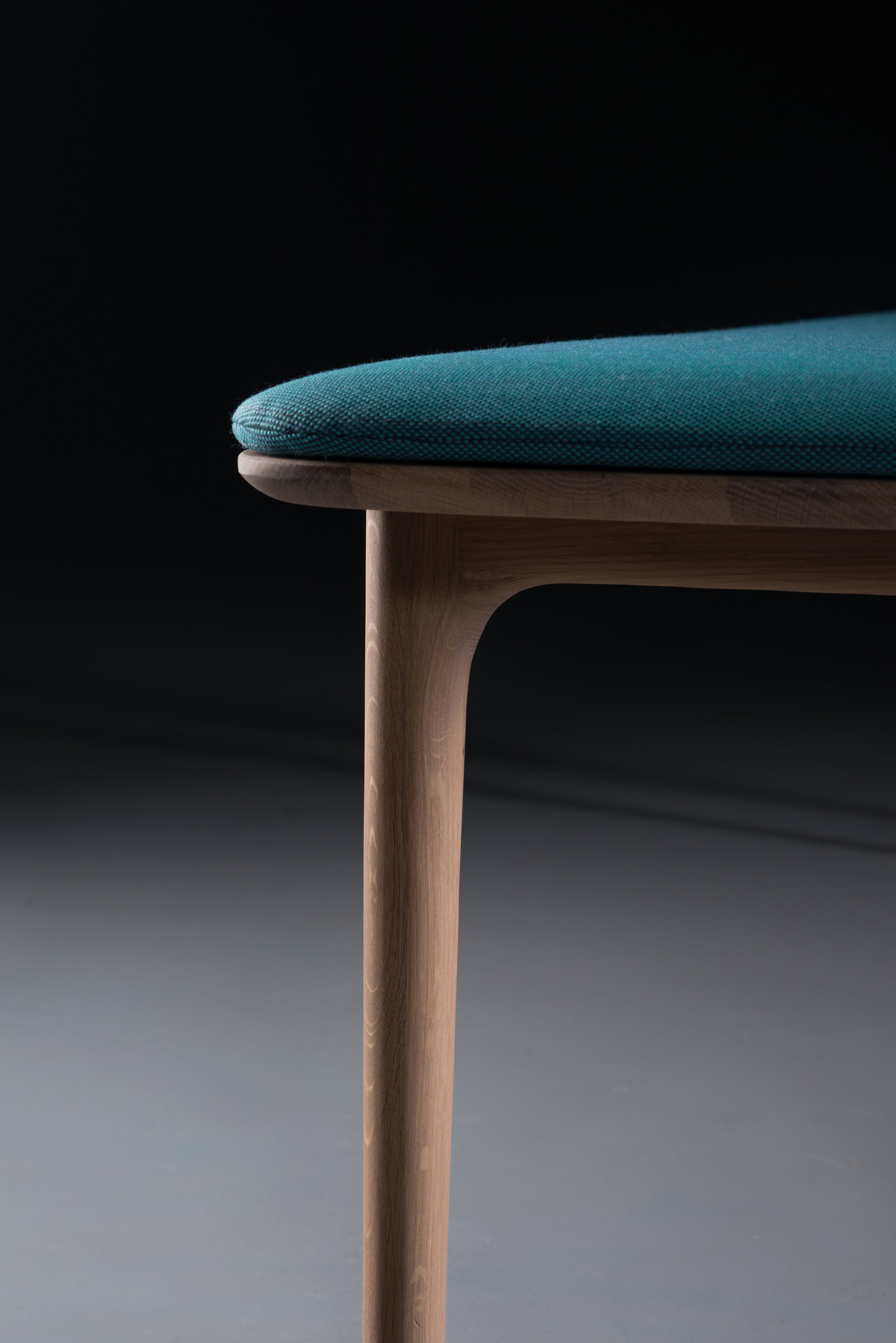 Neva bench shown from a three-quarter angle, highlighting its balanced proportions and wood craftsmanship.