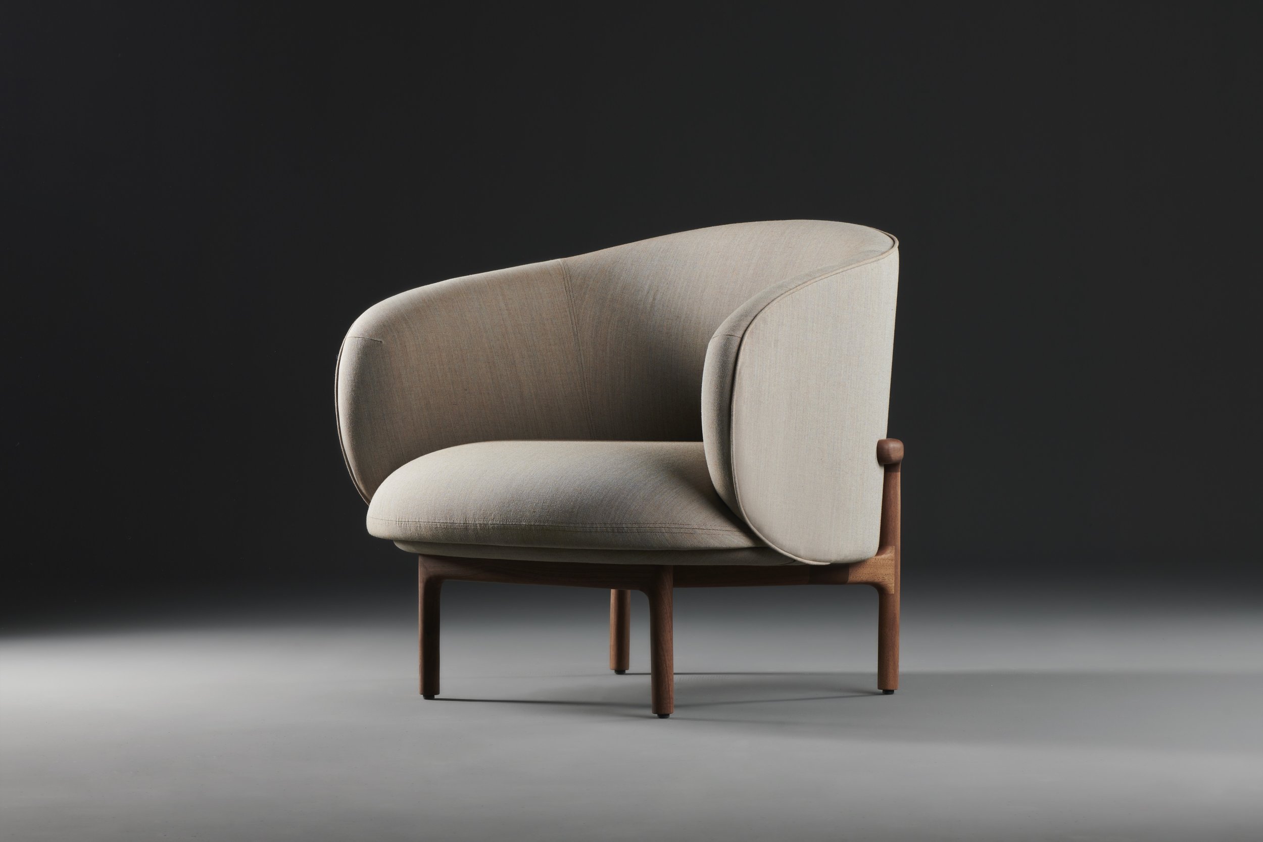 Mela Lounge Trimmed with flowing upholstered seat and backrest, supported by a solid wood frame, combining comfort and refined design.