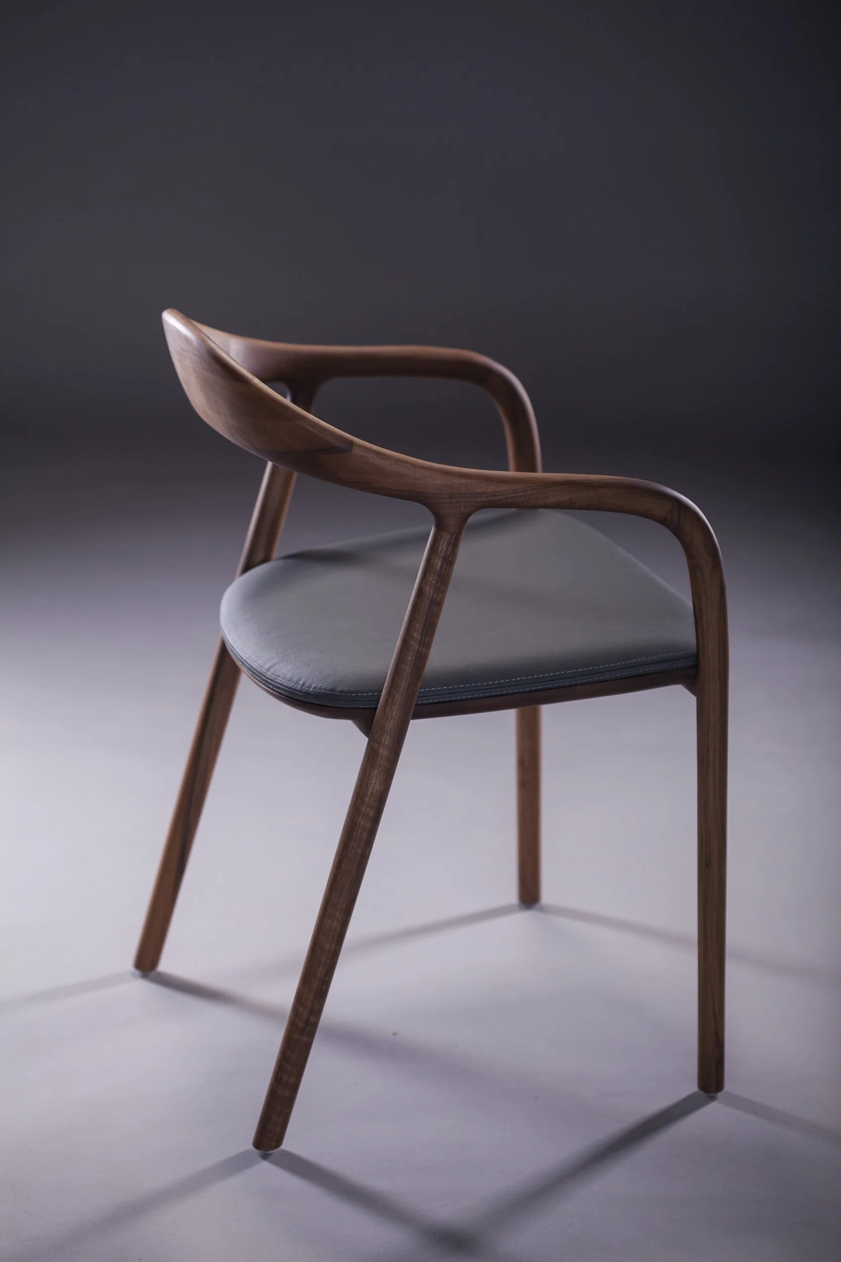Close-up of Neva Chair backrest and armrest showing seamless wood craftsmanship