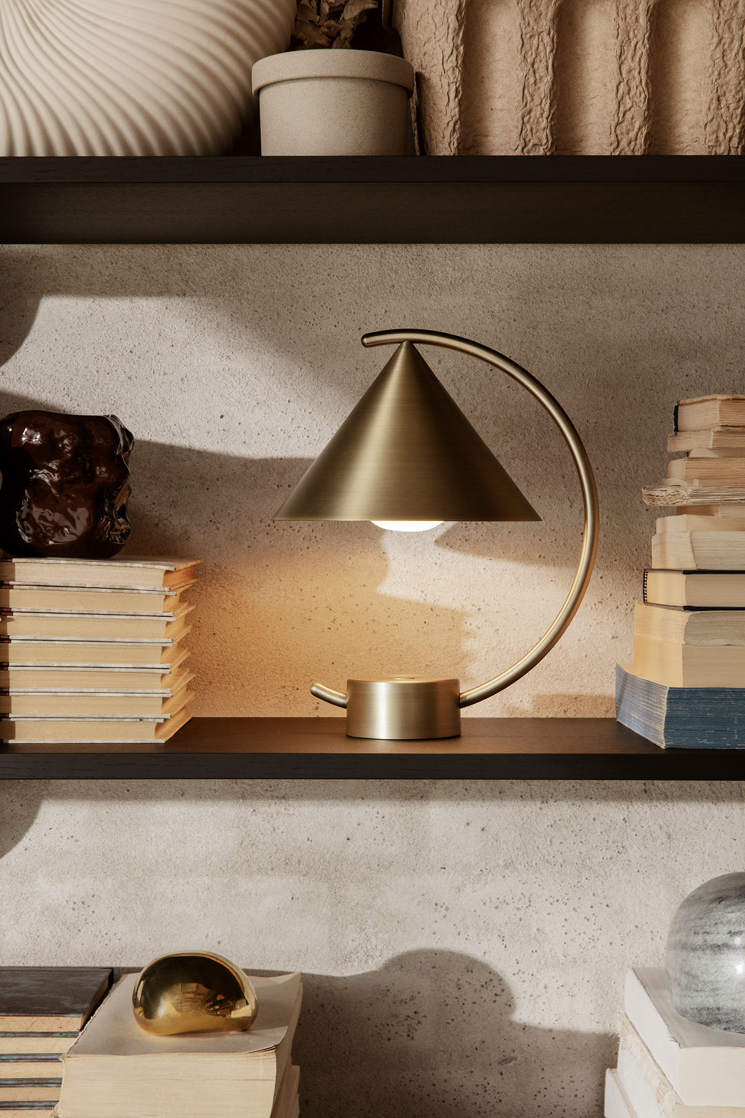 Meridian lamp illuminating a surface, showcasing its simple geometric form and dynamic sliding feature that changes the direction and composition of light.