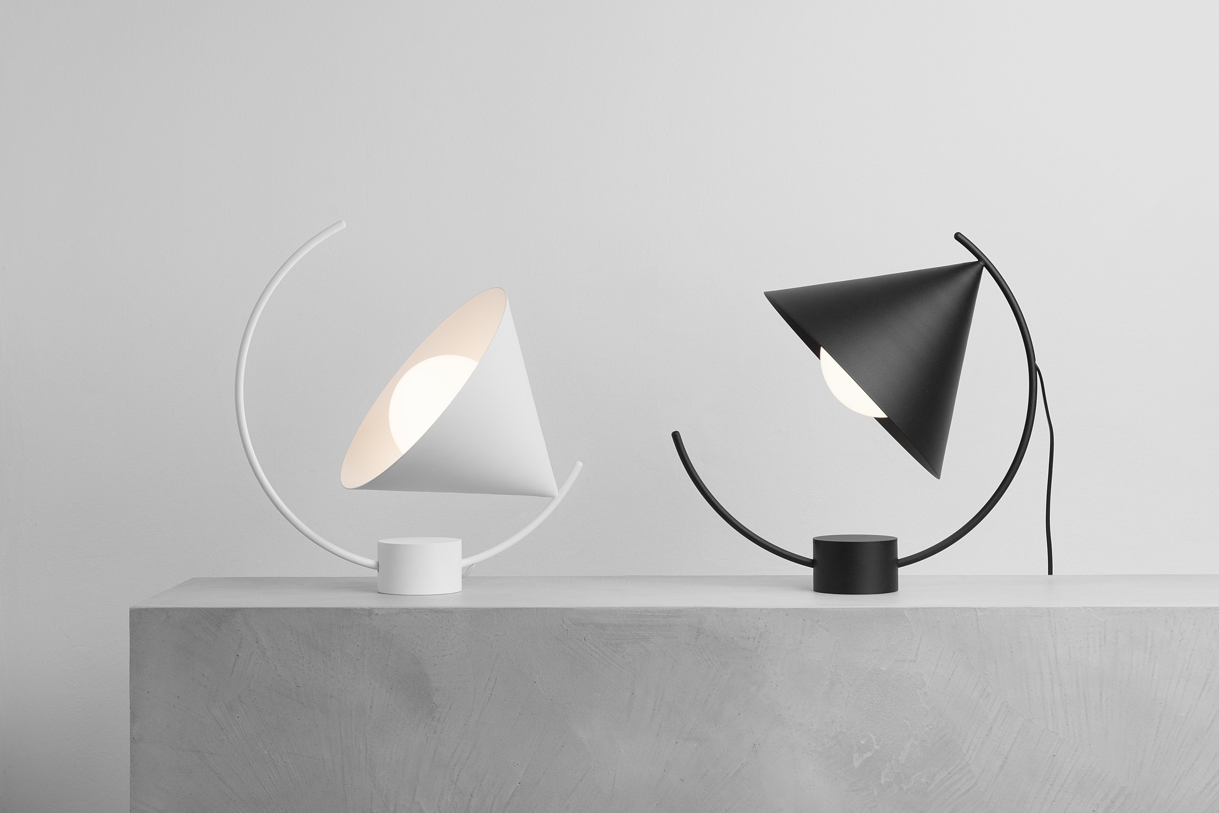 Meridian table lamp by Regular Company for Ferm Living, featuring a minimalist geometric design with a sliding mechanism that allows light to travel along a sculptural path.