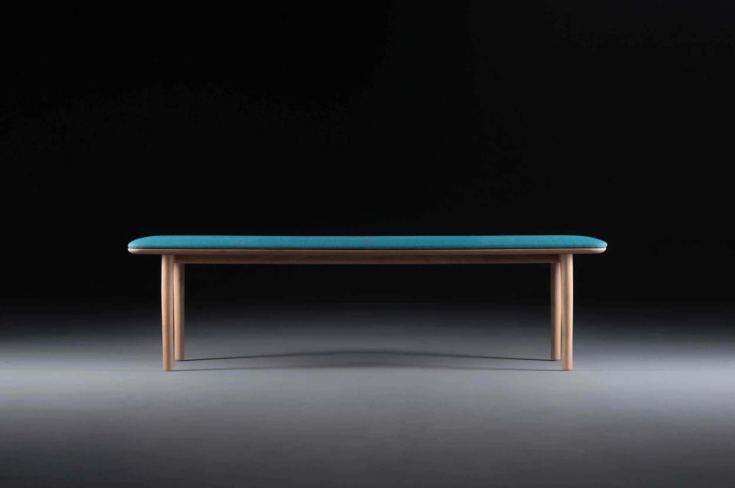 Neva bench shown from a three-quarter angle, highlighting its balanced proportions and wood craftsmanship.