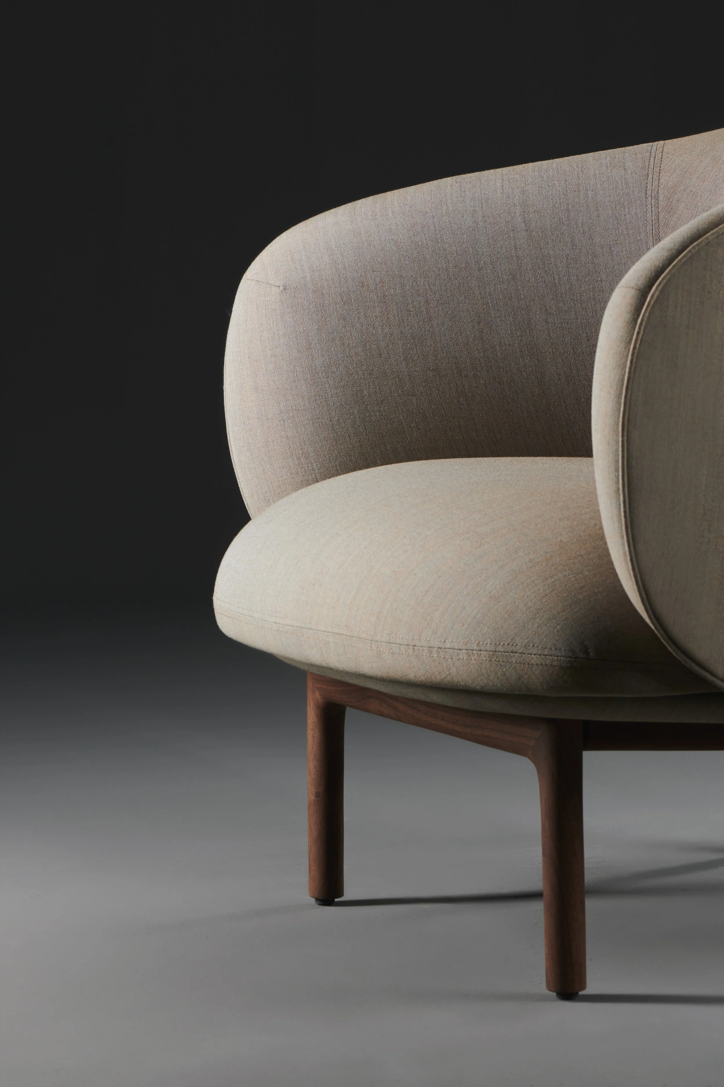 Mela Lounge Trimmed with flowing upholstered seat and backrest, supported by a solid wood frame, combining comfort and refined design.