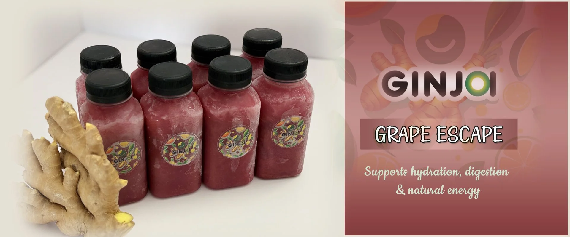 Six bottles of ginger and grape juice on a white surface with a ginger root in the foreground. The right side of the image has a promotional graphic for GINJO grape escape, with text indicating it supports hydration, digestion, and natural energy.