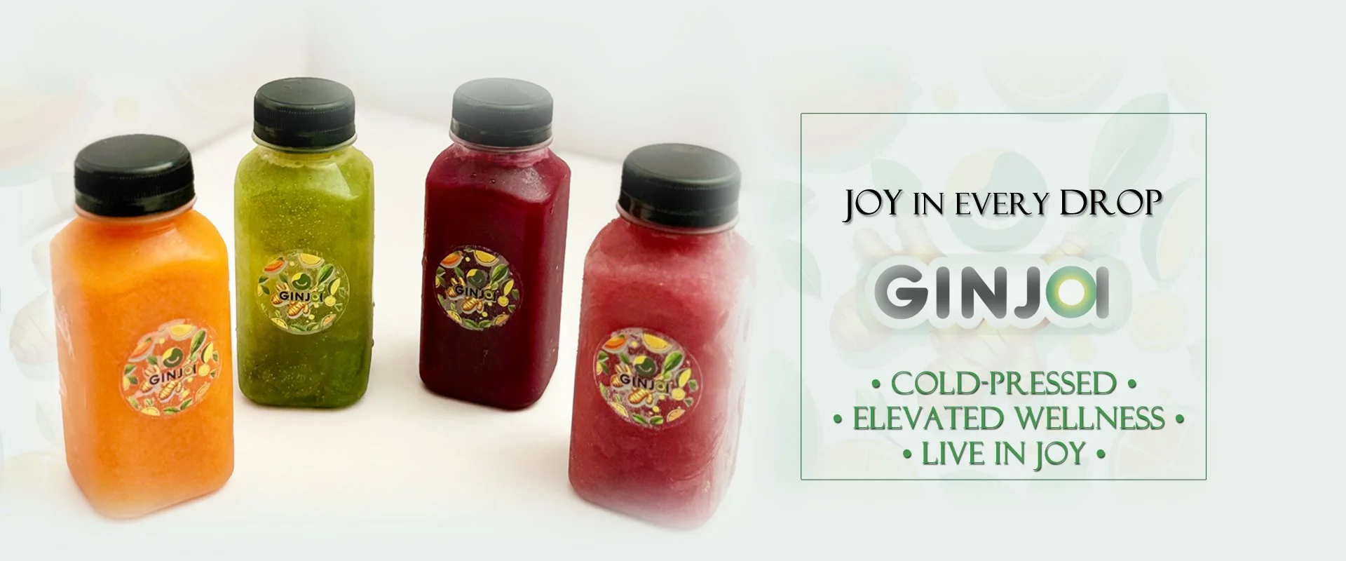 Four bottles of colorful juice with black caps on a white surface, with a text overlay promoting GINJO cold-pressed juices and their benefits