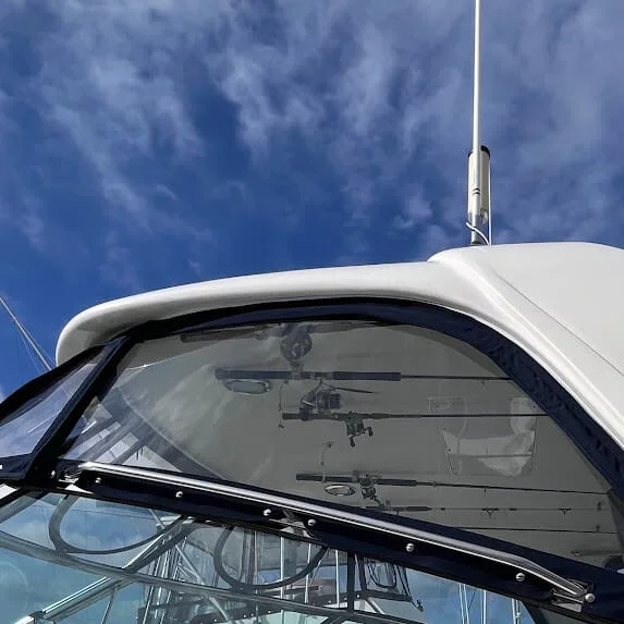 Close-up of the side enclosure panel custom made by Robie Canvas, against a partly cloudy blue sky.