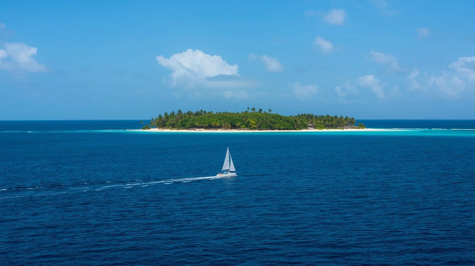 A sailboat sailing by a deserted island