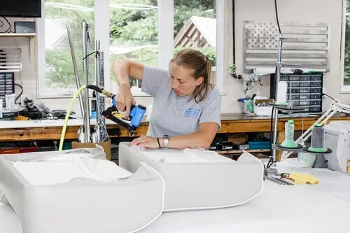 Woman working on a repair project in a workshop or garage.