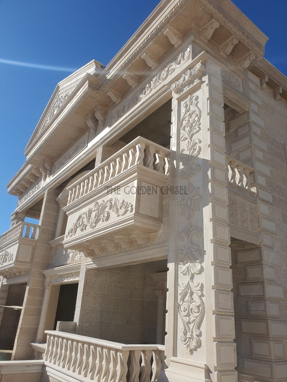 واجهة فيلا فاخرة من الحجر الطبيعي مع شرفات مزخرفة ونقوش حجرية يدوية وأعمدة كلاسيكية | Luxury natural stone villa facade with ornate balconies, hand-carved stone details, and classical columns