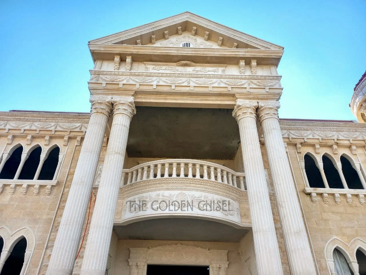 Ornate stone facade with carved columns, decorative panels, and architectural details