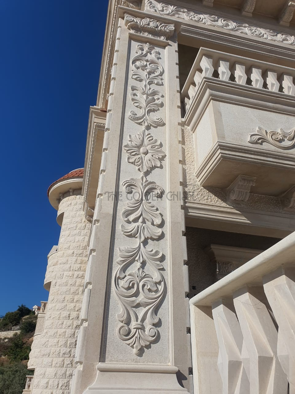 تفاصيل نحت حجري يدوي على واجهة فيلا فاخرة مع زخارف نباتية وأقواس وشرفات حجرية | Hand-carved stone details on a luxury villa facade with floral ornaments, arches, and stone balconies