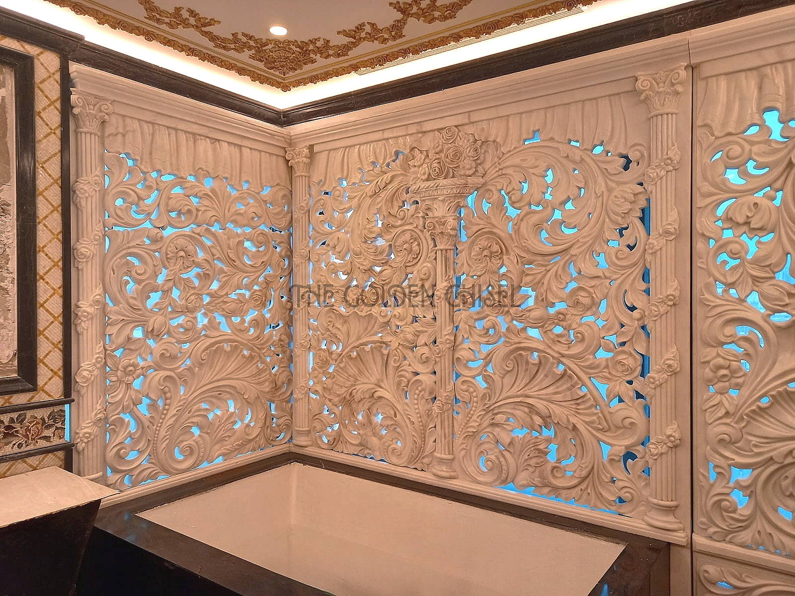 تصميم داخلي فاخر بألواح حجرية ورخامية منحوتة بزخارف نباتية كلاسيكية. Luxury interior with hand-carved stone panels and elegant classical floral details.