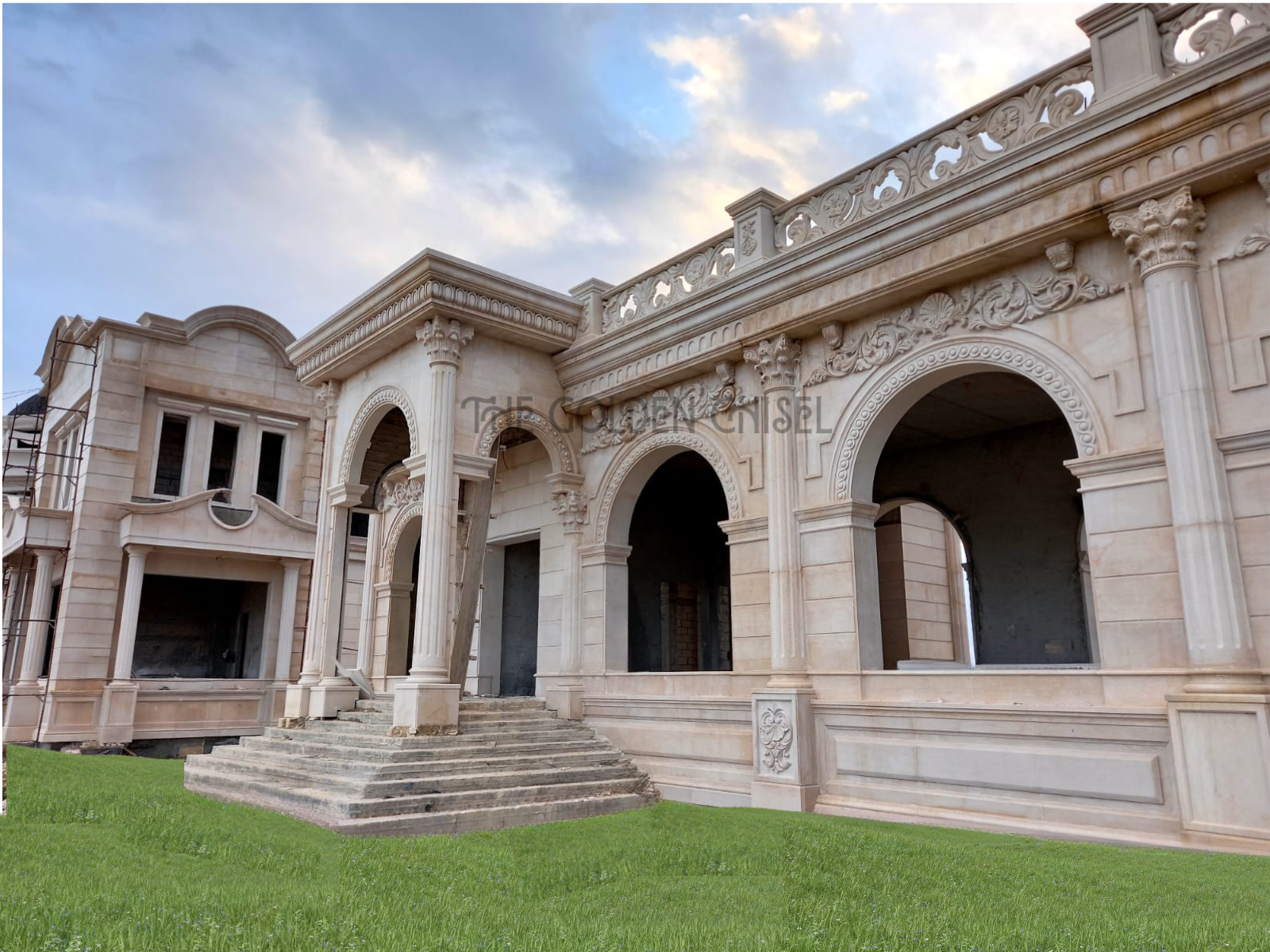 واجهة فيلا فاخرة من الحجر الطبيعي مع أقواس وأعمدة وزخارف كلاسيكية منحوتة. Luxury natural stone villa facade with carved arches, columns and classical ornamentation.
