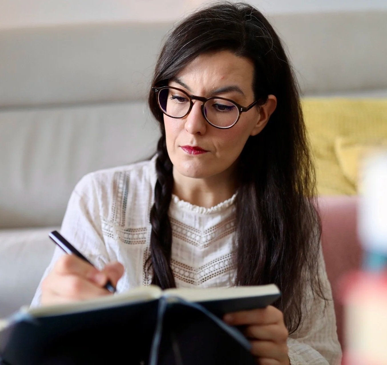 mujer concentrada escribiendo en una libreta con pluma