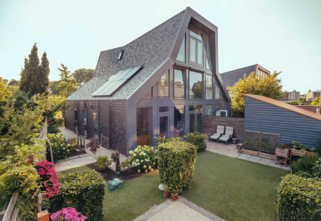 Moderne woning met grote glasramen en een bloeiende tuin.