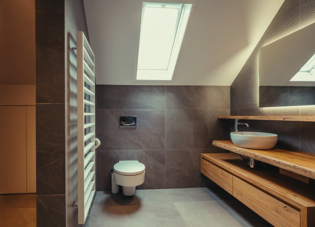 Moderne badkamer met houten wastafelmeubel en donkerbruine tegels.