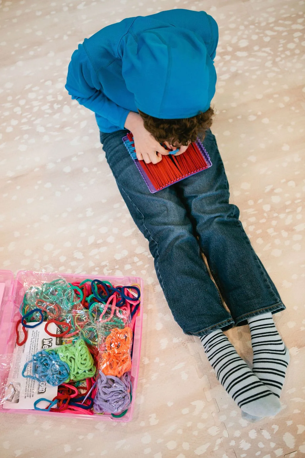 Child sitting on the floor creating with fabric at The Bright Spot.