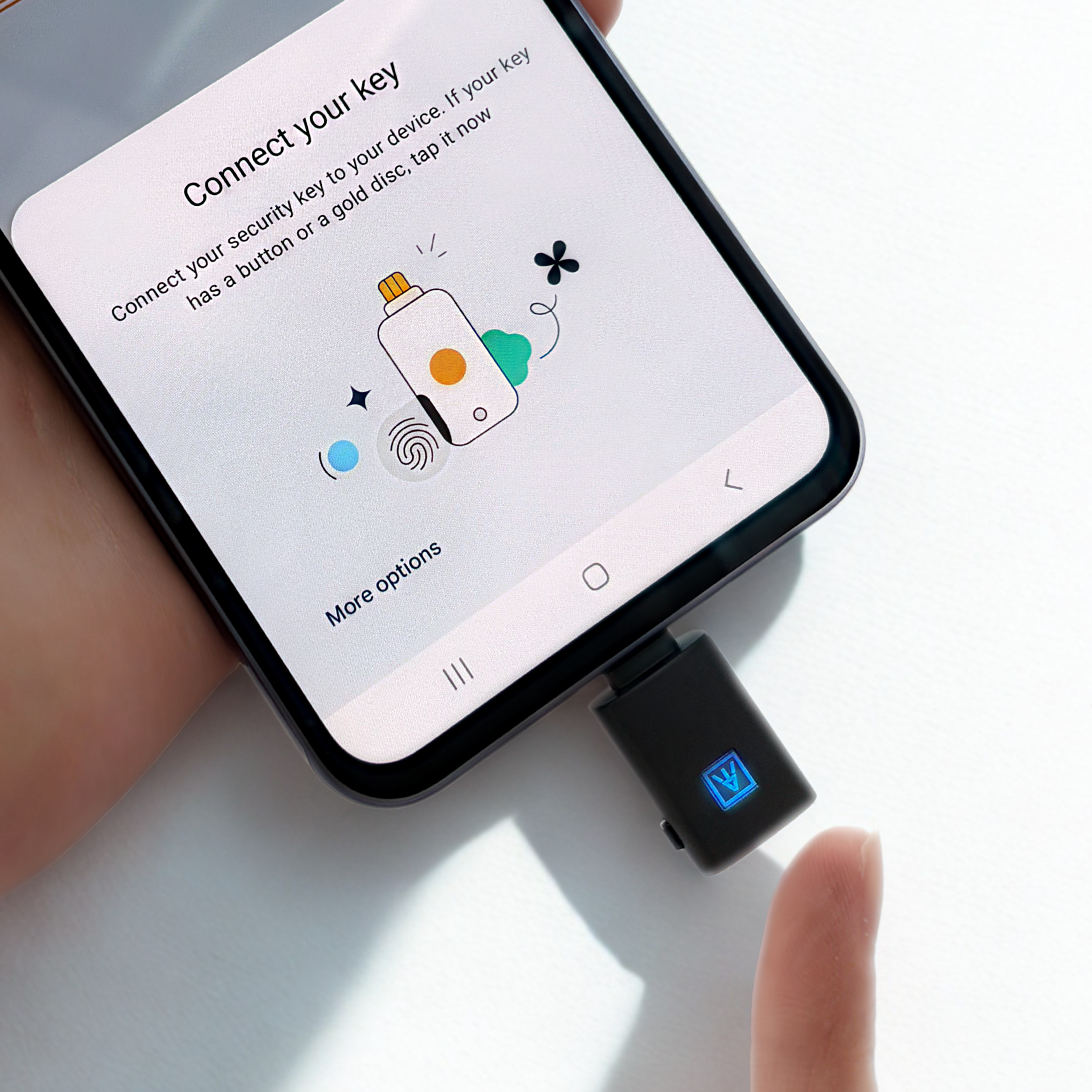 Smartphone screen showing instructions to connect a security key device by tapping it on the phone. The phone is connected to a black security key with a blue logo.